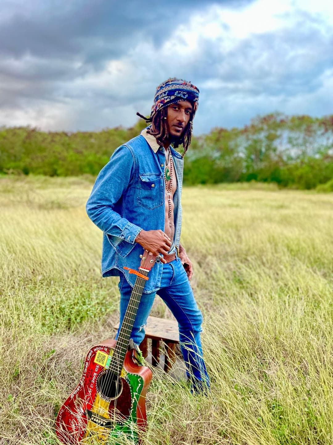 Ky-Enie King in the field with guitar